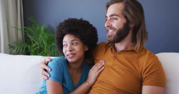 Couple Mixte Course Embrassant Tout Étant Assis Sur Canapé Maison — Video