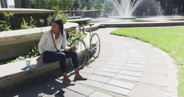 アフリカ系アメリカ人の女性が市内の公園でコーヒーを飲む デジタル ノマドや街中で — ストック動画