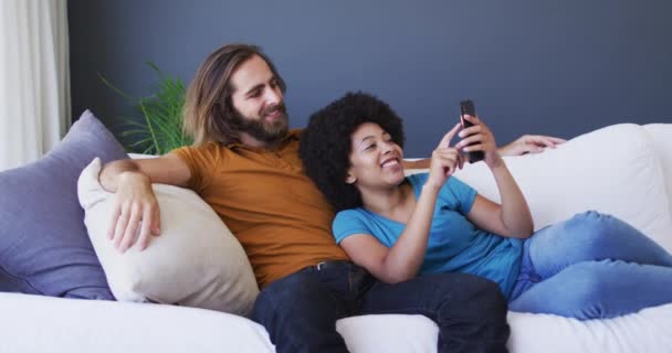Couple Mixte Ayant Vidéocall Sur Smartphone Sur Canapé Maison Rester — Video