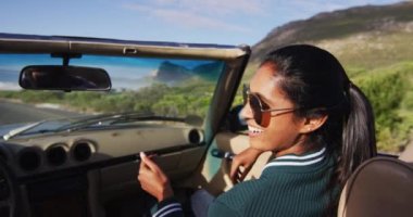 Afro-Amerikalı kadın üstü açık arabada otururken kocasıyla konuşuyor. Yolculuk ve macera konsepti