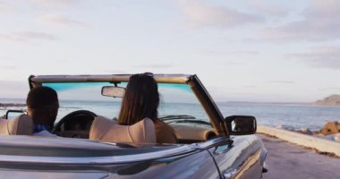 Afro-Amerikalı çift yolda üstü açık arabadan iniyorlar. Yolculuk ve macera konsepti