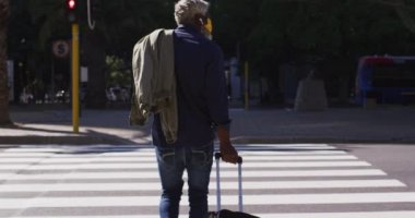 Tramvay çantalı Afro-Amerikan son sınıf öğrencisinin karşıdan karşıya geçişi. Coronavirus covid-19 salgınında hijyen ve sosyal mesafeler.