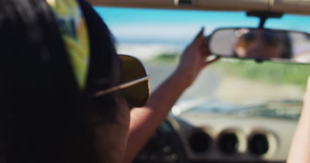 Mujer Afroamericana Ajustando Espejo Retrovisor Mientras Está Sentada Coche Convertible — Vídeo de stock