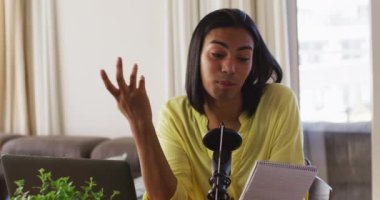 Karışık ırk değişkeni evde dizüstü bilgisayar okuyarak podcast yapıyor. Karantina süresince evde tecrit altında kalmak.