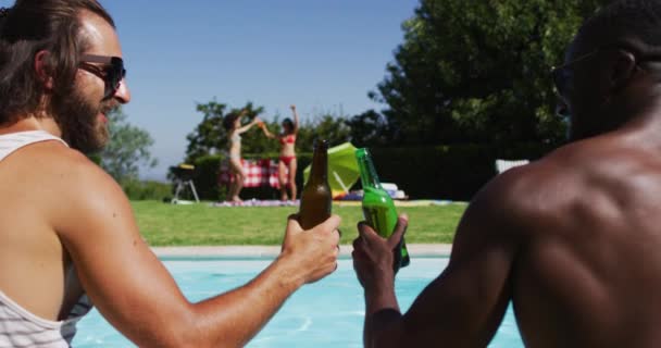 Dos Amigos Masculinos Diversos Brindando Bebiendo Cerveza Mientras Están Sentados — Vídeos de Stock