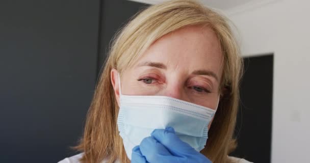 Caucasian Senior Female Doctor Wearing Surgical Gloves Adjusting Face Mask — Stock Video