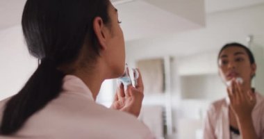 Karışık ırk sıvısı olan insan banyoda duruyor ve tıraş köpüğü sürüyor. Karantina süresince evde tecrit altında kalmak.