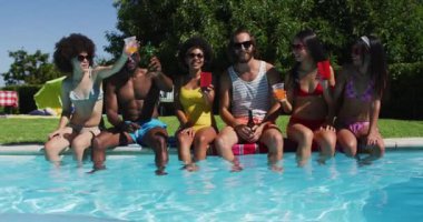 Çeşitli arkadaşlar havuz kenarında otururken içki kızartıyorlar. Gençlik arkadaşlığı ve havuz partisi konsepti