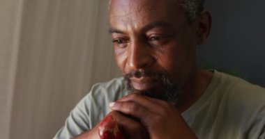 Evinde baston tutan Afrikalı Amerikalı adamı yakından çek. Karantina karantinasında tek başına evde kalmak