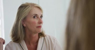 Kafkasyalı son sınıf öğrencisi, banyo aynasına bakıp saçını tarıyor. Karantina süresince evde tecrit altında kalmak.