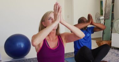 Evde birlikte yoga yapan çeşitli son sınıf çiftleri. Karantina süresince evde tecrit altında kalmak.