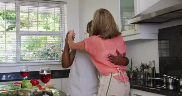 Mutfakta Yemek Hazırlarken Önlük Giyip Dans Eden Farklı Yaşlı Çiftler — Stok video