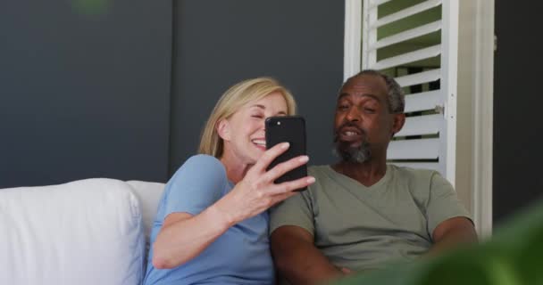 Couple Senior Mixte Prenant Selfie Sur Smartphone Tout Étant Assis — Video