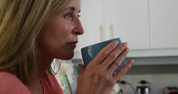 Biała Starsza Kobieta Stojąca Kuchni Pijąca Kawę Przebywanie Domu Izolacji — Wideo stockowe