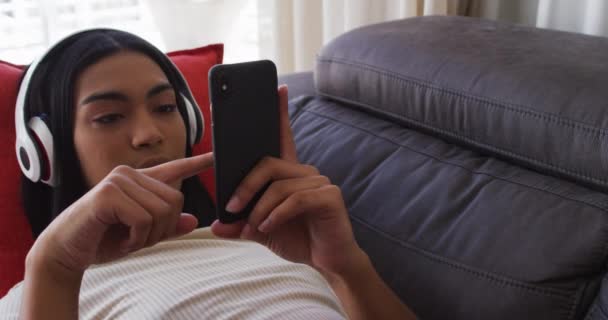 인종성 유동성 스마트폰을 사용하고 집에서 음악을 소파에 있습니다 봉쇄되어 고립된 — 비디오