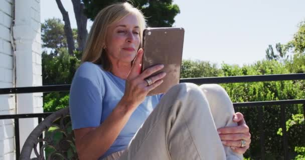 Donna Anziana Caucasica Utilizzando Tablet Seduto Giardino Soleggiato Stare Casa — Video Stock
