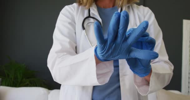Midsection Caucasian Senior Female Doctor Putting Surgical Gloves Hygiene Healthcare — Stock videók