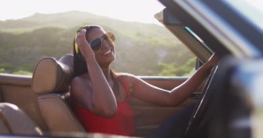 Üstü açık arabada oturan Afro-Amerikan kadın portresi. Yolculuk ve macera konsepti