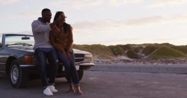 Afrika kökenli Amerikalı çift yolda dikilirken bir yönü işaret ediyor. Yolculuk ve macera konsepti