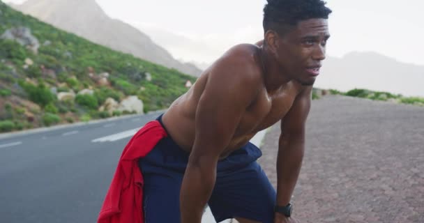 Homem Afro Americano Exercitando Livre Apoiando Joelhos Uma Estrada Costeira — Vídeo de Stock