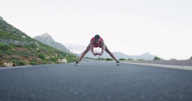 Afrika kökenli Amerikalı bir adam esneme egzersizi yapıyor ve yolda koşuyor. fitness sporları ve sağlıklı yaşam tarzı konsepti