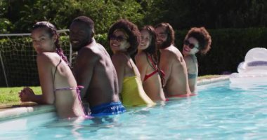 Çeşitli arkadaş grupları havuz başında kameraya bakıyor. Yazın dışarıda takılır ve dinlenir..