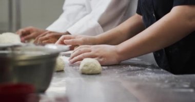 İki farklı kadın aşçı restoran mutfağında hamur hazırlıyor ve konuşuyor. Yoğun bir lokanta mutfağında çalışıyorum..
