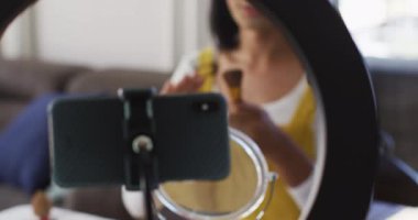 Karışık cinsiyet sıvısı vlog kaydedicisi evde makyaj videosu kaydediyor. Karantina süresince evde tecrit altında kalmak.