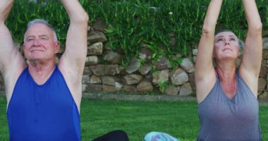 Kafkasyalı son sınıf çifti bahçede yoga yapıyor. Karantina tecrit kavramında kişisel tecrit