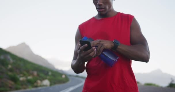 Afro Amerikaanse Man Houdt Waterfles Met Behulp Van Smartphone Weg — Stockvideo