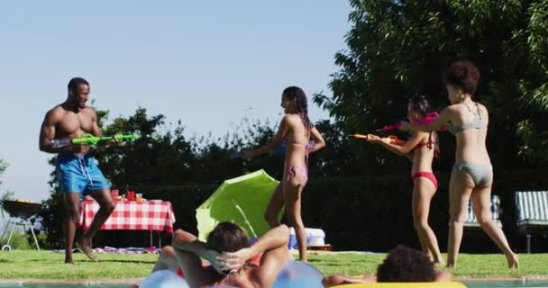 混血儿在游泳池里玩水枪很开心 夏天在户外消磨时光 — 图库视频影像