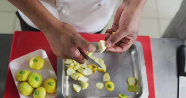 レストランキッチンで野菜を切る混合レースの男性シェフの中間部 忙しいレストランのキッチンで働く — ストック動画