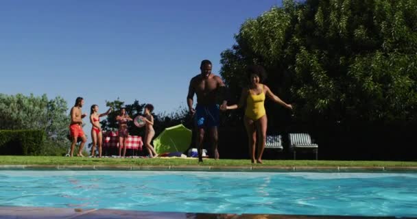 水泳プールに飛び込む楽しみを持っている友人の多様なグループ 夏には屋外でリラックスして — ストック動画