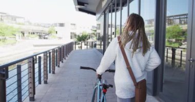 Sokakta bisiklet süren melez bir yarışçı ve rastalı biri. Yeşil kentsel yaşam tarzı, şehirde geziyor..