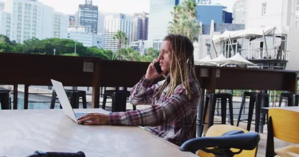 Kafenin Dışındaki Masada Dizüstü Bilgisayar Akıllı Telefon Kullanarak Oturan Rastalı — Stok video