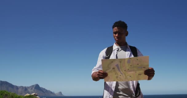Αφροαμερικάνος Κάνει Πεζοπορία Διαβάζοντας Ένα Χάρτη Στην Παράκτια Ύπαιθρο Προπόνηση — Αρχείο Βίντεο