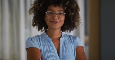 Kıvırcık saçlı, kameraya bakıp gülümseyen melez bir kadının portresi. Coronavirus covid 19 salgını sırasında dışarı çıkmış..