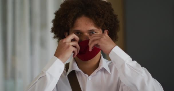 赤い顔のマスクに巻き毛の混じった男の肖像 コロナウイルスが19種のパンデミックを起こし — ストック動画