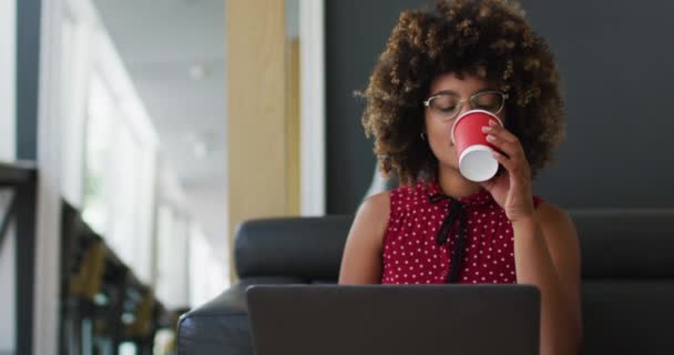 Ανάμεικτη Γυναίκα Που Περνάει Γραφειοκρατικά Πίνοντας Καφέ Χρησιμοποιώντας Λάπτοπ Στο — Αρχείο Βίντεο