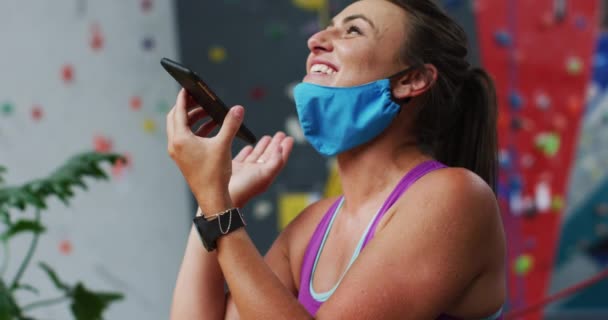 Mulher Branca Rindo Com Máscara Facial Usando Smartphone Parede Escalada — Vídeo de Stock