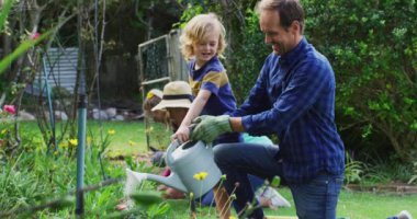 Beyaz bir baba ve oğul bahçede çiçek suluyor ve aileleriyle bahçeyle uğraşıyor. Mutlu üç kuşak aile evde birlikte vakit geçiriyor..