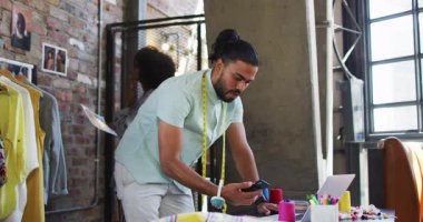 Çeşitli erkek ve kadın moda tasarımcıları akıllı telefondan konuşuyor ve resimlerini asıyor. bağımsız yaratıcı tasarım işi.