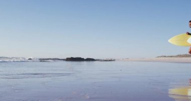 Sahilde sörf tahtası olan Afrikalı Amerikalı bir çift. Tatil ve deniz kenarında sağlıklı vakit geçirme zamanı..