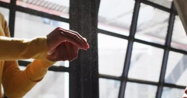 Karışık ırk erkek kafe çalışanı kadın iş arkadaşının ellerini dezenfekte ediyor. Coronavirüs covid 19 salgını sırasında küçük bağımsız iş.