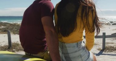 Kumsal arabasında oturup konuşan mutlu beyaz bir çift. Yaz tatili gezisinde plaj durağı.