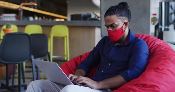Hombre Afroamericano Con Mascarilla Cafetería Usando Laptop Nómada Digital Movimiento — Vídeo de stock