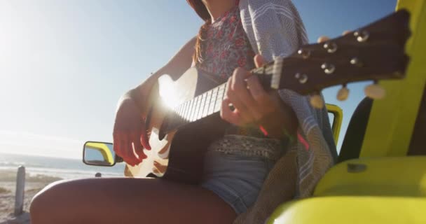 Szczęśliwa Biała Kobieta Siedząca Plażowym Buggy Nad Morzem Grająca Gitarze — Wideo stockowe