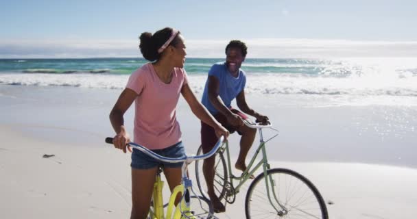 Afrikanskt Amerikanskt Par Ler Och Cyklar Stranden Hälsosam Fritid Utomhus — Stockvideo