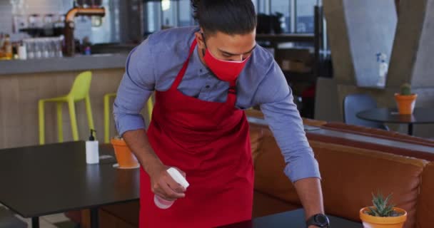 Mixed Race Male Cafe Worker Wearing Face Mask Disinfecting Table — Stock Video