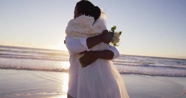 恋爱中的非洲裔美国人结婚了 日落时拥抱在海滩上 爱情和浪漫 海边度假 — 图库视频影像